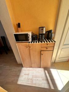 Fewo Warnemünde في روستوك: طاولة مطبخ مع ميكروويف وأواني وأواني قهوة