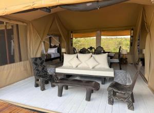 a room with a couch and chairs in a tent at Mara Major Camp in Masai Mara +132 photos