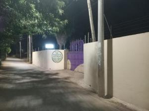 a fence with a purple gate on a street at night at The Truenorth apartments chitiri in Diani Beach