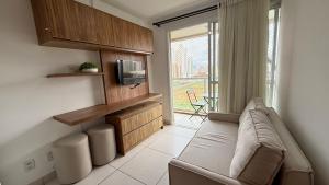 a living room with a couch and a tv at Blend - 1 Quarto 2 Camas 1 Vaga in Brasília