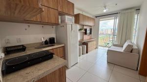 a kitchen with a stove and a white refrigerator at Blend - 1 Quarto 2 Camas 1 Vaga in Brasília