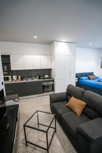 ein Wohnzimmer mit Sofa und eine Küche in der Unterkunft De Luca 6 Apartments - Vinto House Collections in Salerno