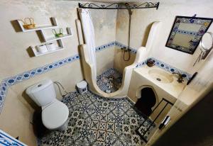 a small bathroom with a toilet and a sink at Authentic Dual Terrace house in Chefchaouene
