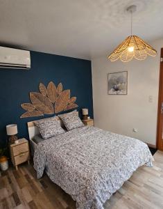 a bedroom with a bed and a blue wall at Chambre privé climatisé in Vertaizon +4 photos