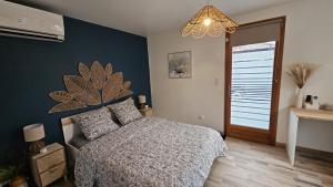 a bedroom with a bed and a blue wall at Chambre privé climatisé in Vertaizon