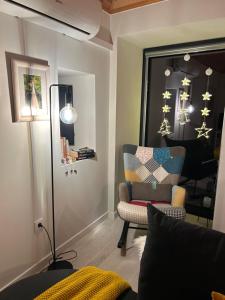 a living room with a chair and a mirror at Casinha Serabigoes Arouca Passadiços Paiva in Arouca