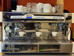 Una máquina de café con tazas encima en Splendor Bratianu, en Piteşti