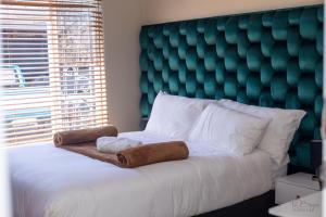een slaapkamer met een groot bed met een groen hoofdeinde bij Makay's Guests house in Kimberley