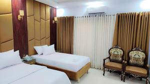 Comfort Lodge في كراتشي: غرفة فندقية بسريرين وكرسي