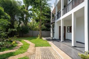 Un patio de un edificio blanco con una pasarela. en Heavens Talpe, en Talpe