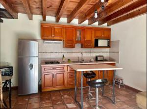 a kitchen with wooden cabinets and a stainless steel refrigerator at Departamento centrico in Durango