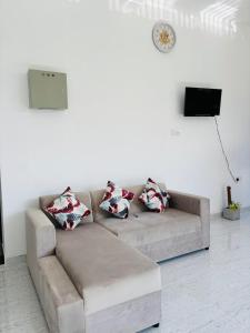 a couch with four pillows in a living room at Brampy Guest in Polonnaruwa +9 photos