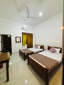 a bedroom with two beds and a ceiling at Brampy Guest in Polonnaruwa