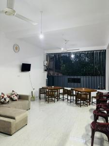 a living room with a couch and tables and chairs at Brampy Guest in Polonnaruwa