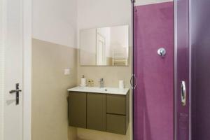 Casa celine moderna, relax, comoda alle spiagge e negozi في شيافاري: حمام مزود بحوض غسيل وباب دش أرجواني +28 صورة