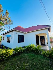 een wit huis met een rood dak bij CnRAirBnB in Iringa