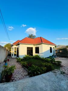 een huis met een rood dak erop bij CnRAirBnB in Iringa