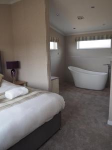 Primrose 1 bed-No Pets-Lily في Horham: غرفة نوم بسرير كبير وحوض استحمام