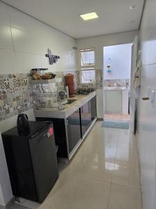 ブルマジーニョにあるCasa de Nair Pousadaの大きなキッチン(カウンター、冷蔵庫付)