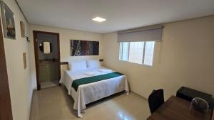 ブルマジーニョにあるCasa de Nair Pousadaのベッドとテーブルのある寝室