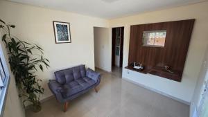 ブルマジーニョにあるCasa de Nair Pousadaのリビングルーム(青い椅子、窓付)