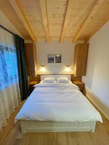 a bedroom with a large white bed with two pillows at Cabana Roua in Borsa