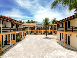 Village do Bosque - Rede Tonziro في بورتو سيغورو: ساحة فارغة لمبنى فيه نخيل