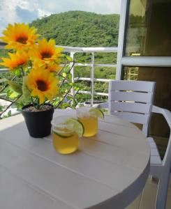 a table with two glasses of orange juice and flowers on it at Moderno Apartamento con Aire Acondicionado - WIFI - Piscina - Aqualina Green - 6 Huéspedes in Girardot