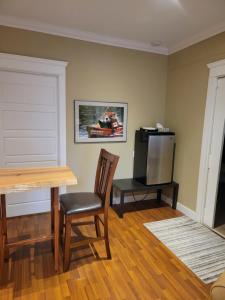 a room with a table and a television and a table and chair at Beaver Hut Bed And Breakfast in Port Alberni