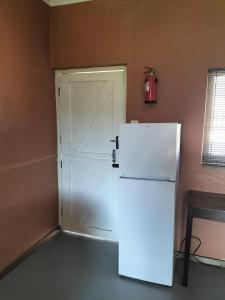 a white refrigerator in a room with a door at Cango's Rest in Oudtshoorn +29 photos