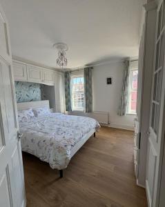 a bedroom with a bed and two windows at Three Bees in Hythe