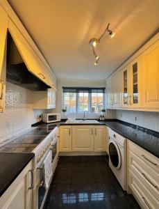 a kitchen with white cabinets and a sink at Three Bees in Hythe