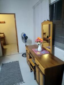 a room with a desk with a vase of flowers on it at Cango's Rest in Oudtshoorn
