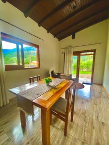 Chalé Mirante في برايا جراندي: غرفة طعام مع طاولة وكراسي خشبية