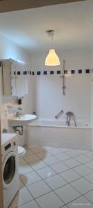 een witte badkamer met een wasmachine en een wastafel bij Cozy Room in München in München +5 foto's