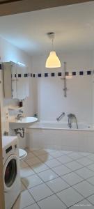 een witte badkamer met een wasmachine en een wastafel bij Cozy Room in München in München