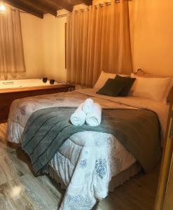 Chalé Mirante في برايا جراندي: غرفة نوم بها سرير عليه منشفتان