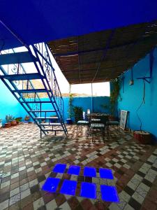 a patio with a table and a blue ceiling at Authentic Dual Terrace house in Chefchaouene +28 photos