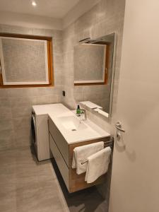 een badkamer met een wastafel en een spiegel bij Dimora Ananthèō in Tirano