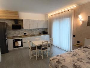 een keuken en eetkamer met een tafel en een bed bij Dimora Ananthèō in Tirano +10 foto's