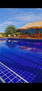 马瑙斯Amazon Tucuna Resort的一座大型蓝色游泳池,后面有一座房子