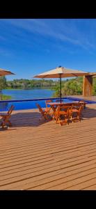 马瑙斯Amazon Tucuna Resort的甲板上配有桌椅和遮阳伞