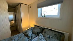 a bedroom with a bed with pillows and a window at Bardufoss Panorama in Bardufoss +21 photos