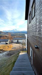 a wooden walkway next to a building with mountains in the background at Bardufoss Panorama in Bardufoss