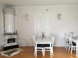 ein weißes Zimmer mit einem Tisch, Stühlen und einem Kamin in der Unterkunft Sweet Dreams B&B Ullared in Ullared