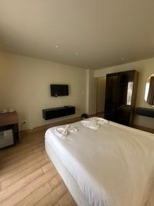 a bedroom with a white bed and a flat screen tv at King's Gate pyramids & sphinx view hotel in Cairo
