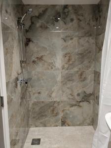 a bathroom with a shower with a stone wall at 2 bedroom house with yard in Cardiff +27 photos