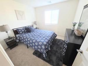 a bedroom with a bed with a blue comforter at 2-Bedroom Entire Guest Suite in North Las Vegas Mountain Views in Las Vegas