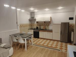 a kitchen with a table and chairs and a refrigerator at Apartament Juliusz Slowacki in Szczawno-Zdrój
