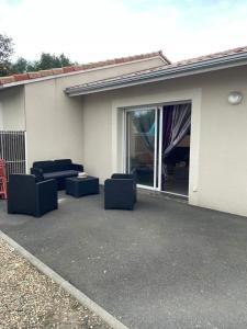 eine Terrasse mit zwei blauen Stühlen und einem Fenster in der Unterkunft Maison Carredas B in Bouliac